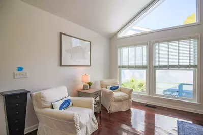 The living room receives lovely natural light through all its nearly floor-to-ceiling windows.