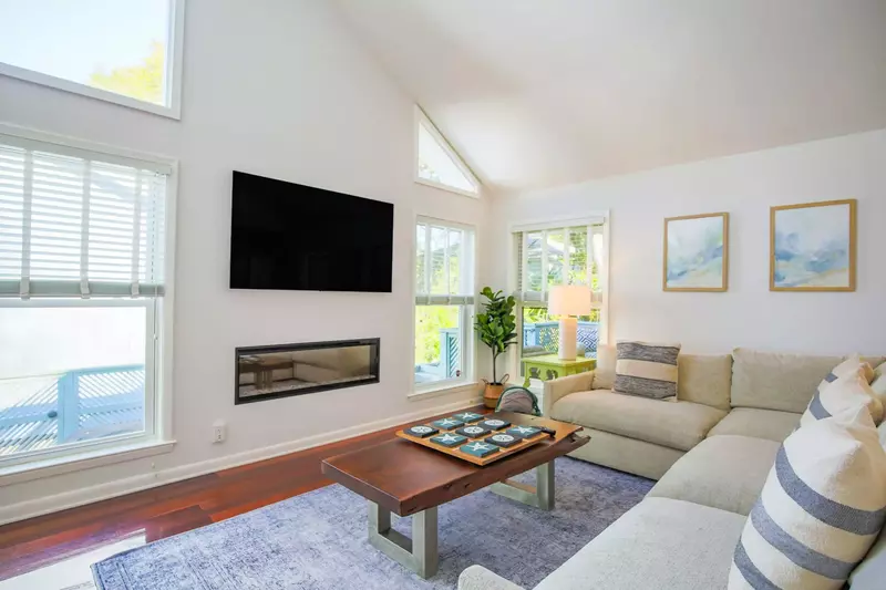 There is a wall-mounted smart TV and large sectional sofa in the living room.