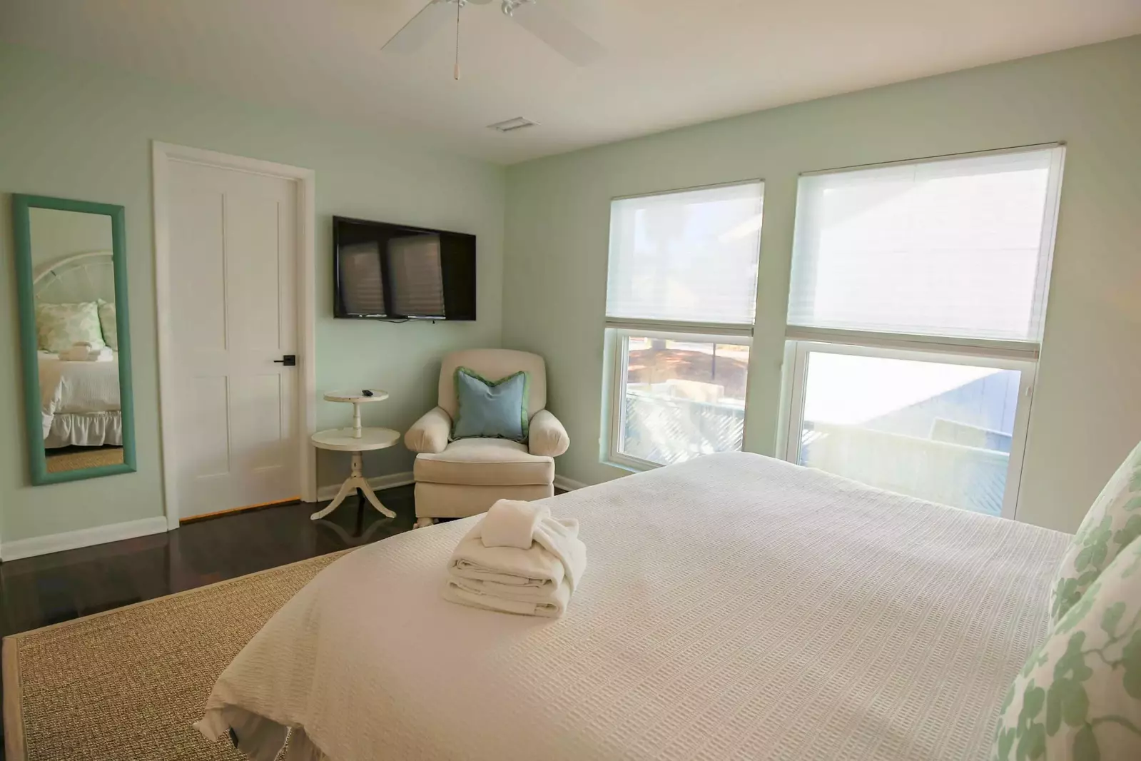 The master suite also features a wall-mounted smart TV and full length mirror.