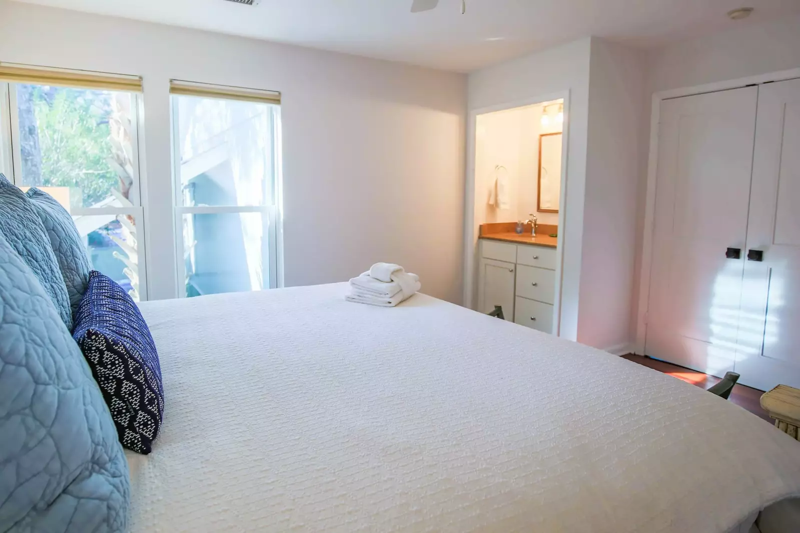 This guest bedroom also has a ceiling fan and a small vanity & sink.