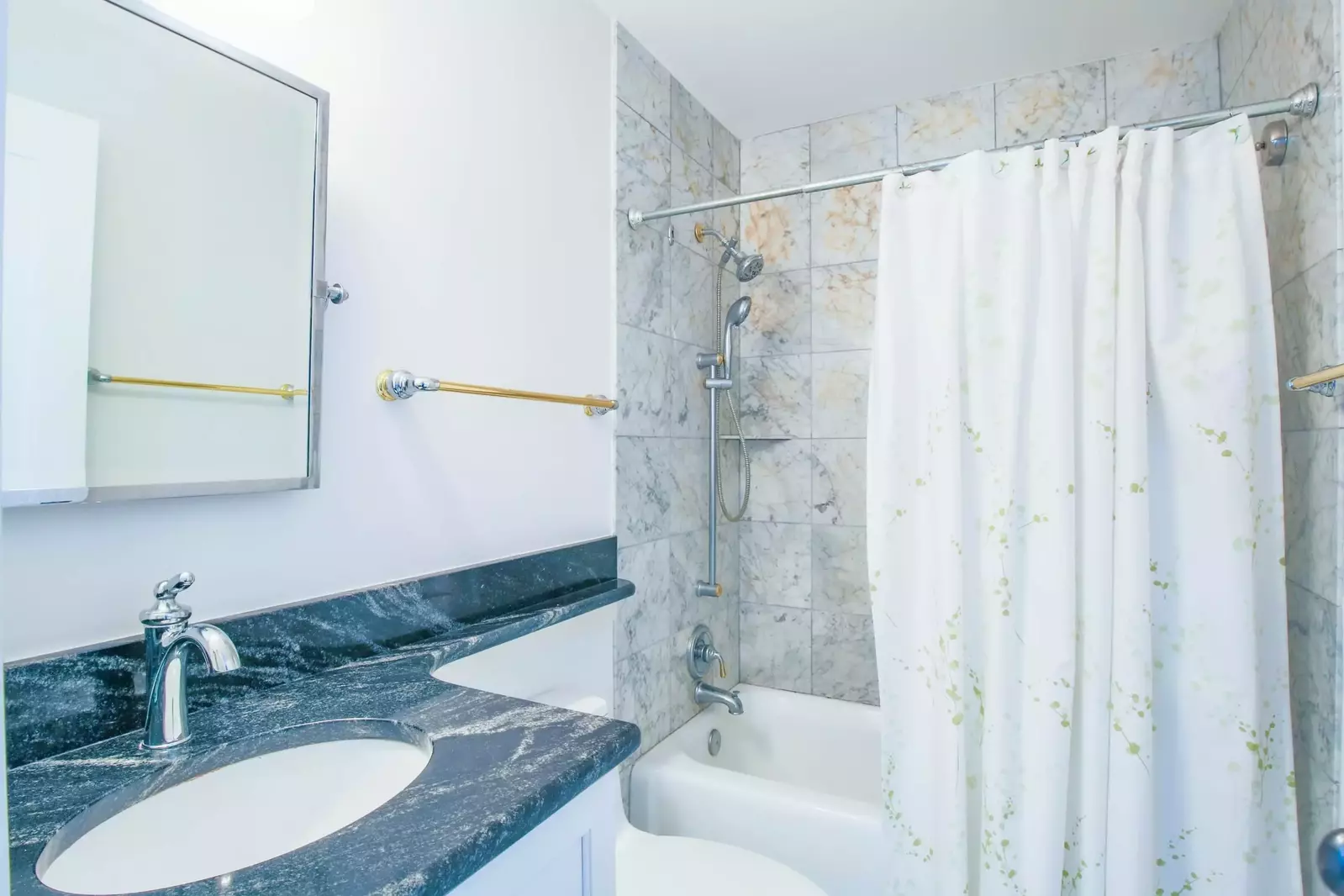 This hallway bathroom with shower/tub combo is shared by the two guest bedrooms.