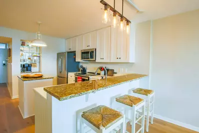 The kitchen features white cabinetry, granite counters and stainless steel appliances.