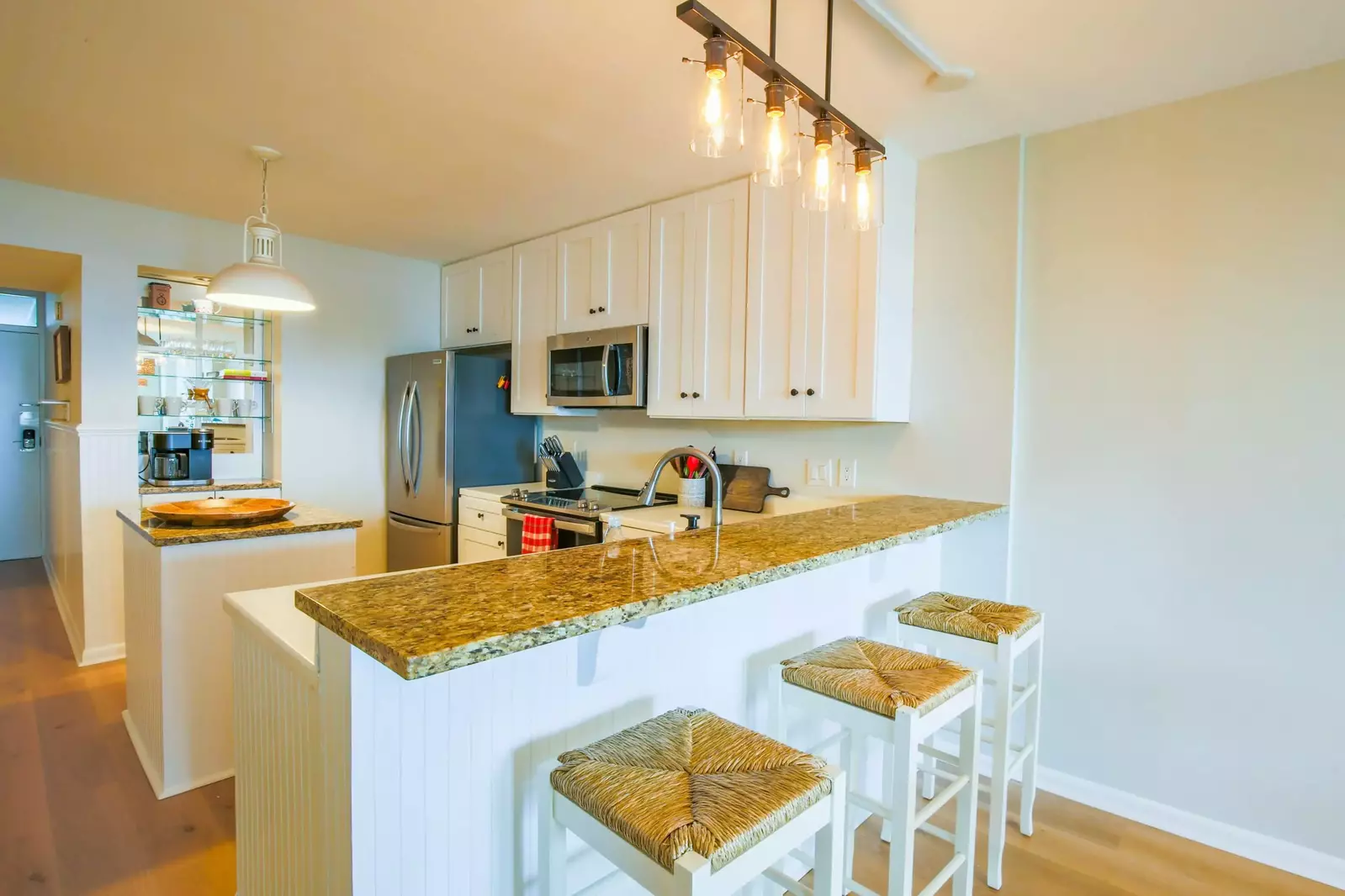 The kitchen features white cabinetry, granite counters and stainless steel appliances.