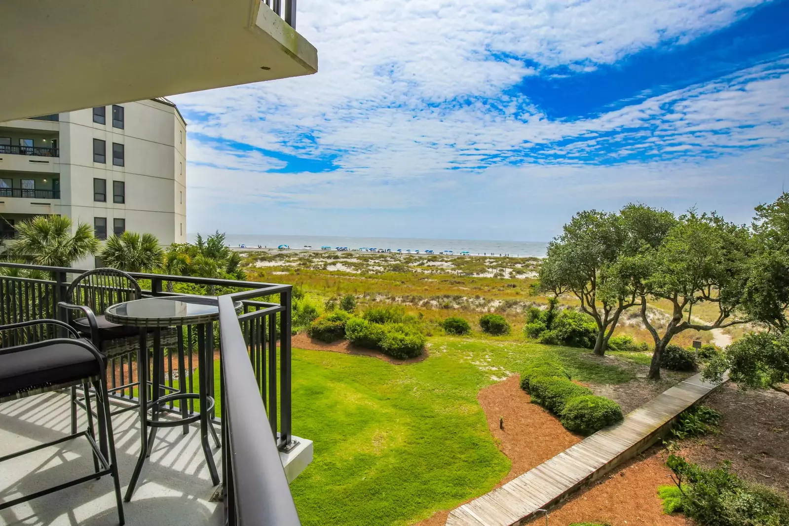 The covered balcony overlooks the Shipwatch boardwalk to the beach, the sand dunes and the ocean.