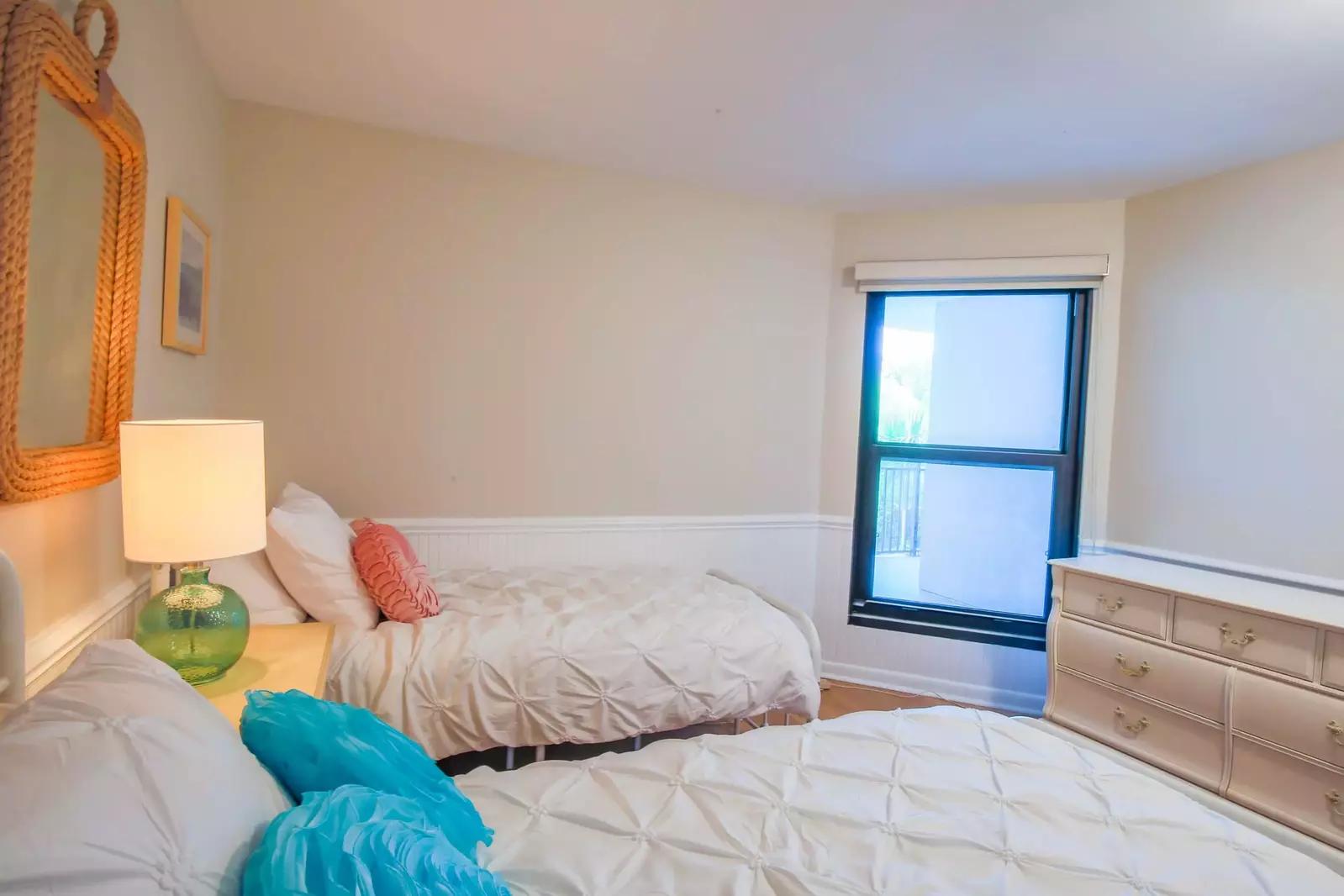 This guest bedroom also has a dresser and shared access to a bathroom.