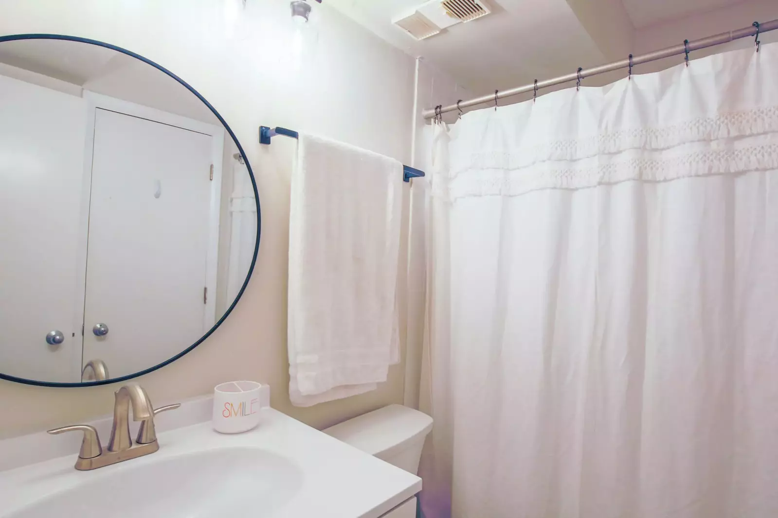 The guest bathroom has a vanity and shower/tub combo.