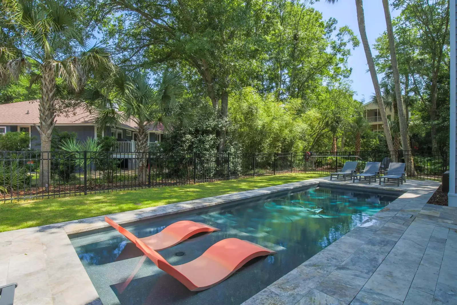 The pool is located within the gated side yard of the home.