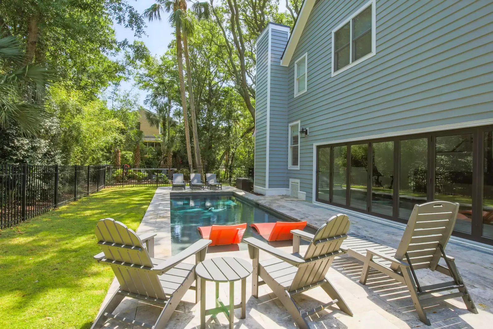 There is outdoor seating alongside the pool.