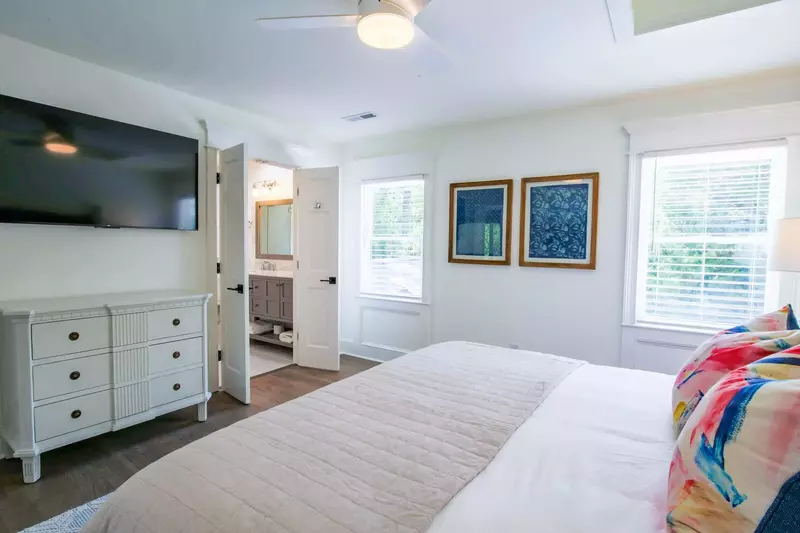 There is also a wall-mounted smart TV and dresser within the master suite.