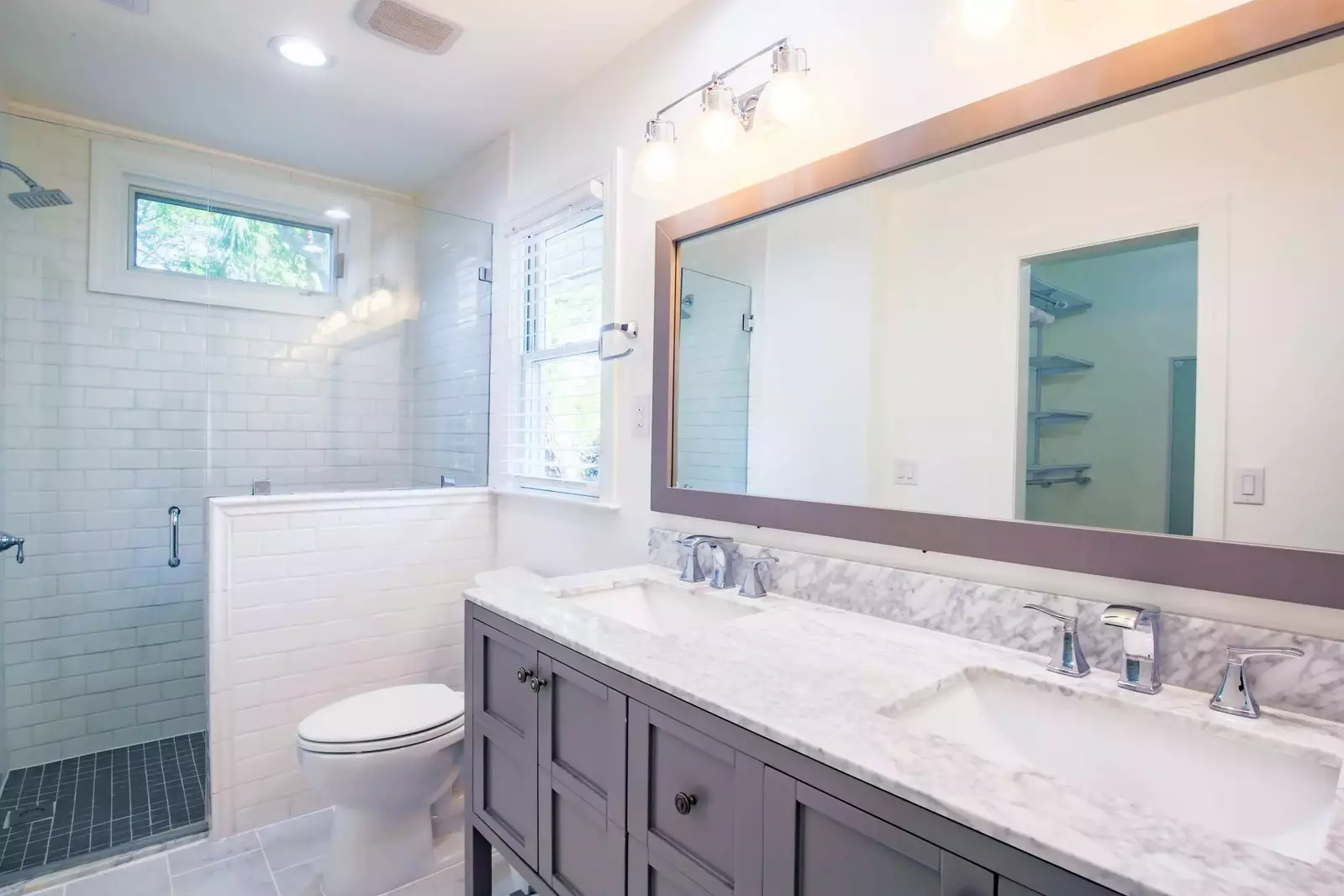 The master bathroom features a double sink vanity and tiled, walk-in shower.