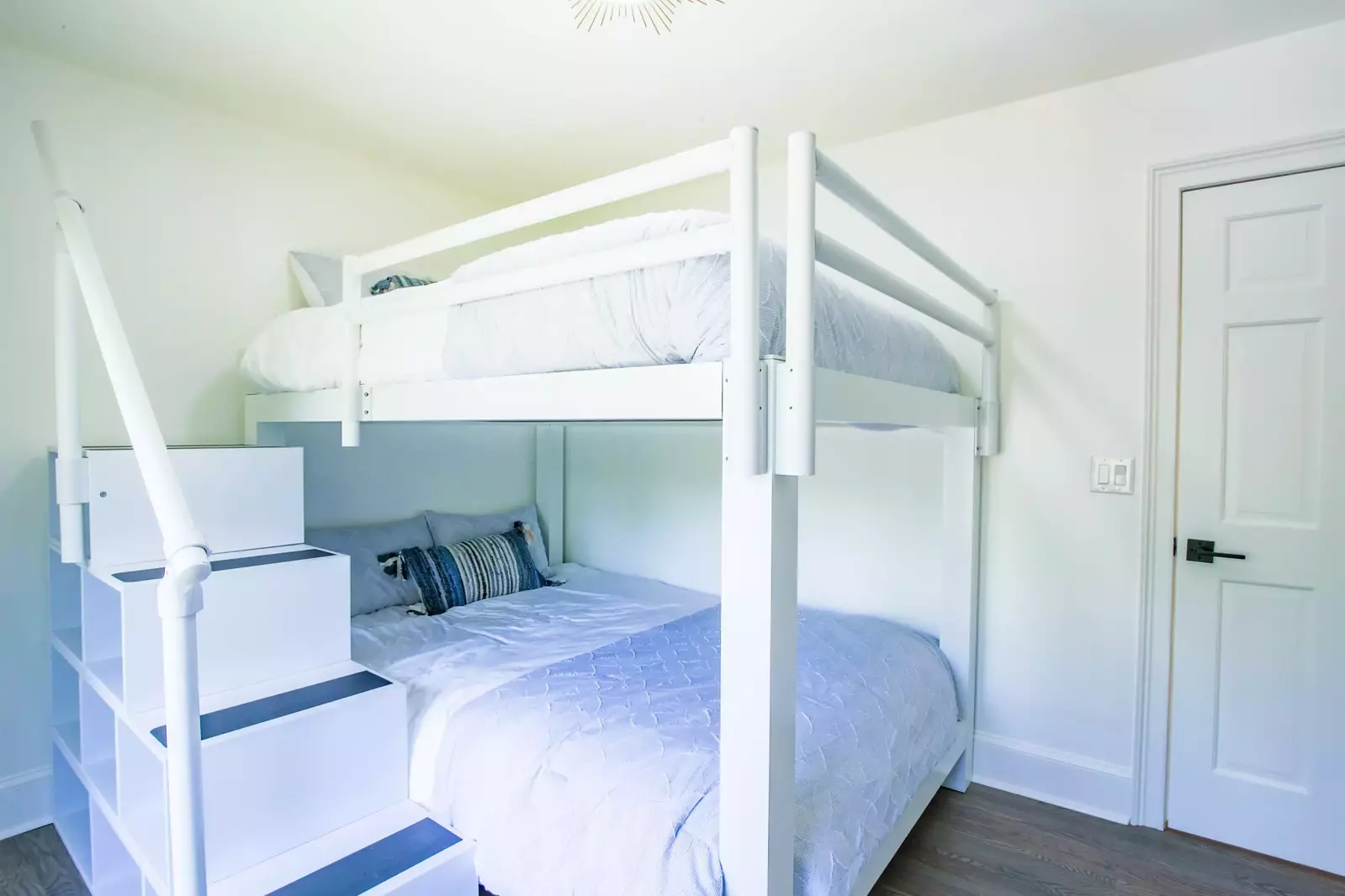 This bunk bedroom has two queen beds and a ladder to reach the upper bunk.