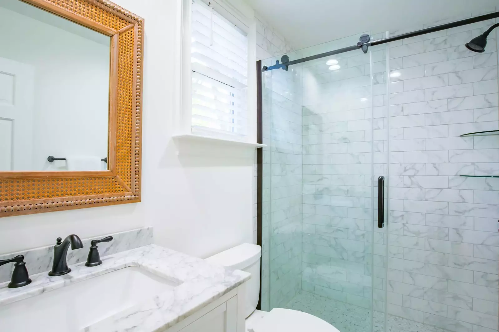 This hallway bathroom with a tiled, walk-in shower is shared by the bunk bedroom and queen bedroom.