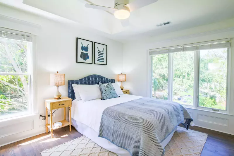 This guest bedroom features a queen bed, night stands with reading lamps and lovely natural light.