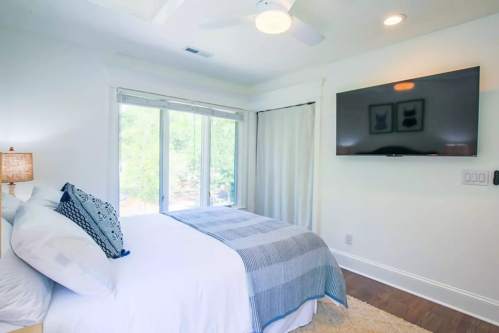 There is also a wall-mounted smart TV, a closet and ceiling fan in this guest bedroom.