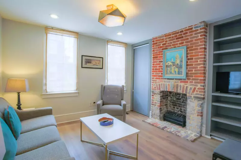 The living room features new flooring and a cozy seating area.