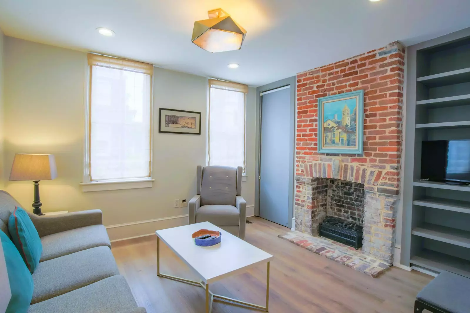 The living room features new flooring and a cozy seating area.