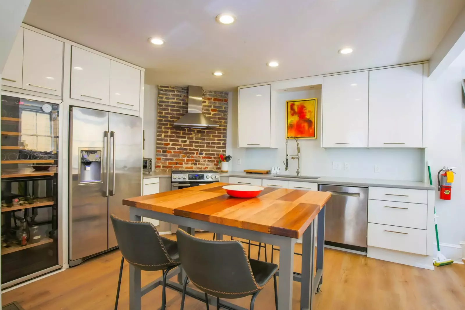 The kitchen features stainless steel appliances, white cabinets and new flooring.