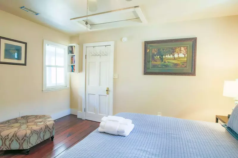 The master suite has an ottoman, ceiling fan and en suite bathroom.