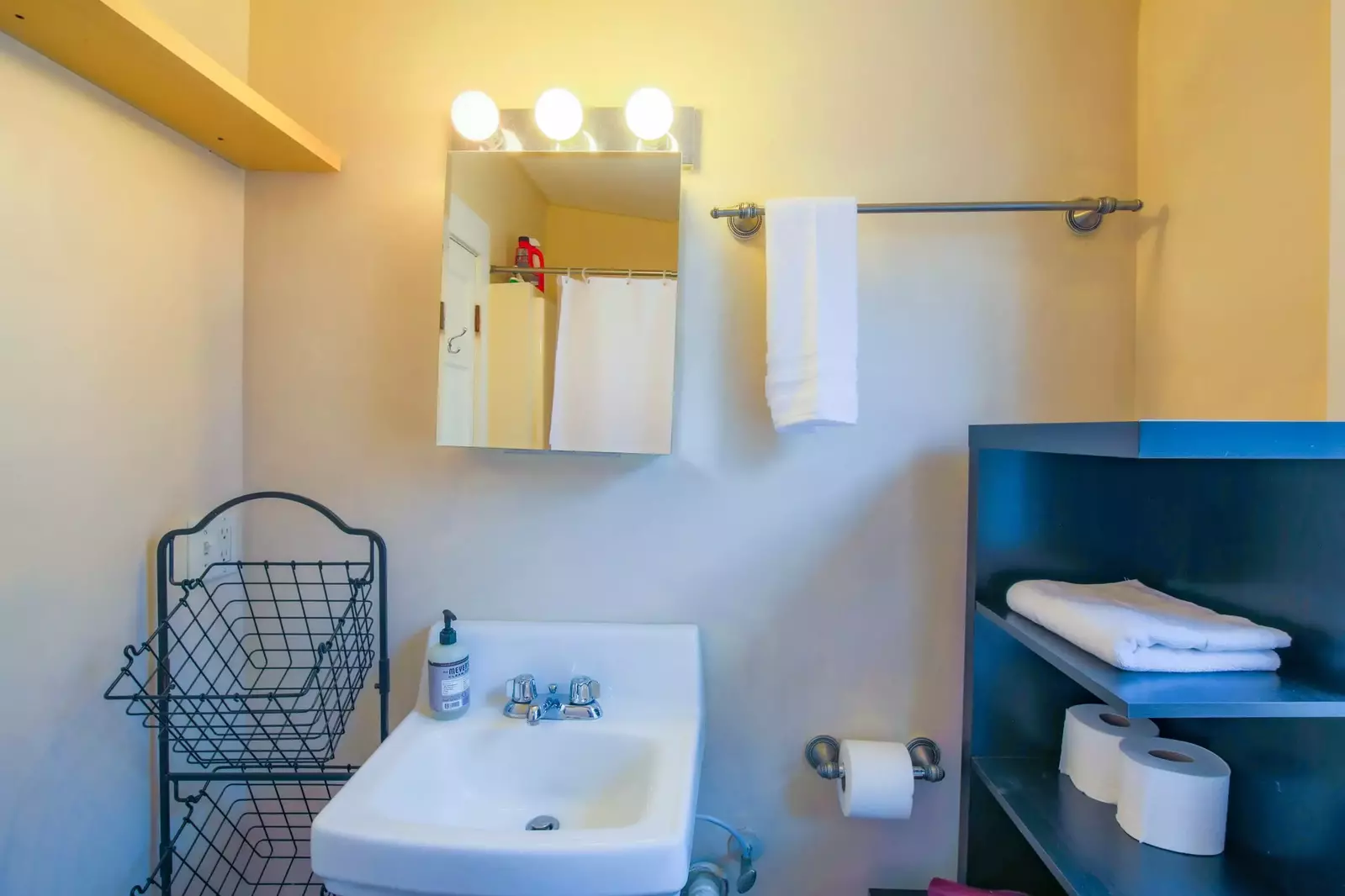 The en suite bathroom has a vanity, medicine cabinet and storage area.
