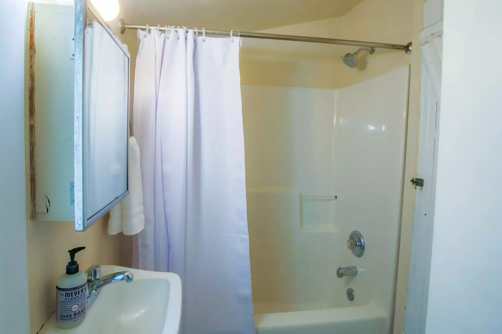 The second bathroom has a vanity and shower/tub combo.