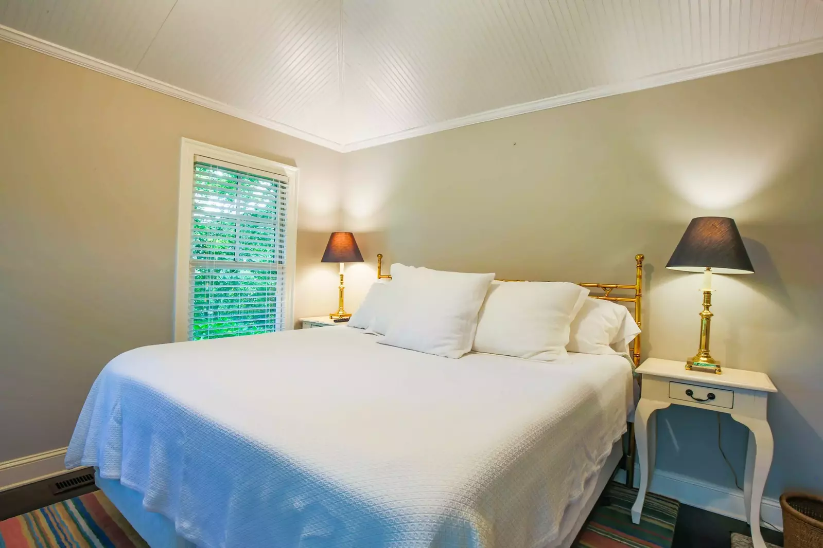 This bedroom, located off of the living room, features a king bed and a tongue and groove ceiling.