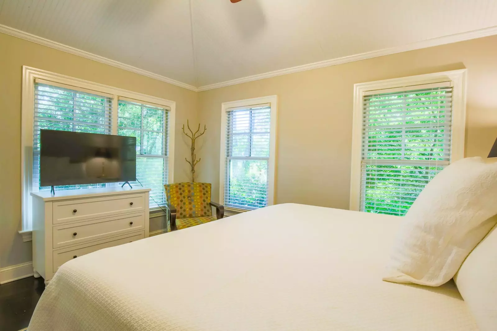 This bedroom also features a dresser, a smart TV and access to the back porch.