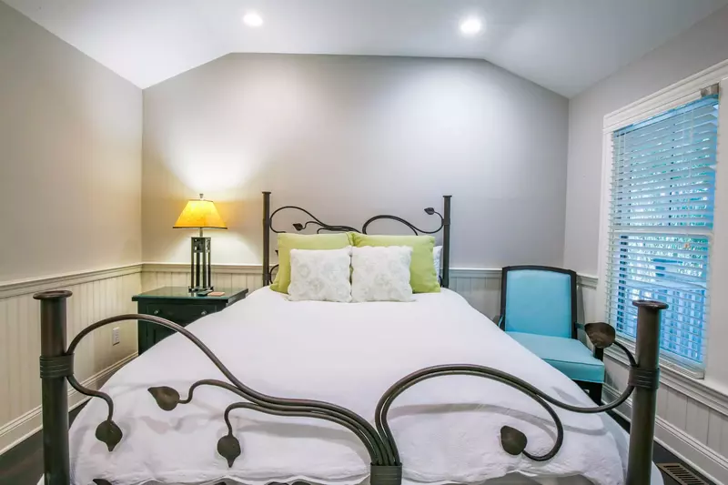 This bedroom features a queen bed and wainscoting.