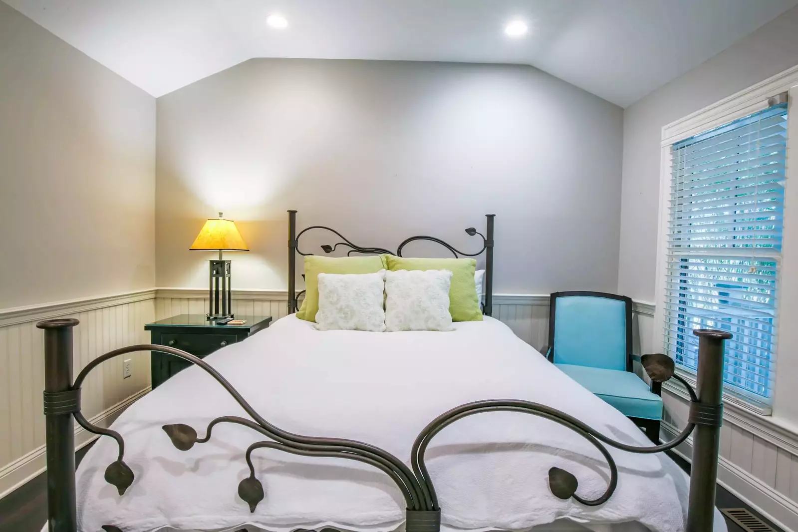 This bedroom features a queen bed and wainscoting.
