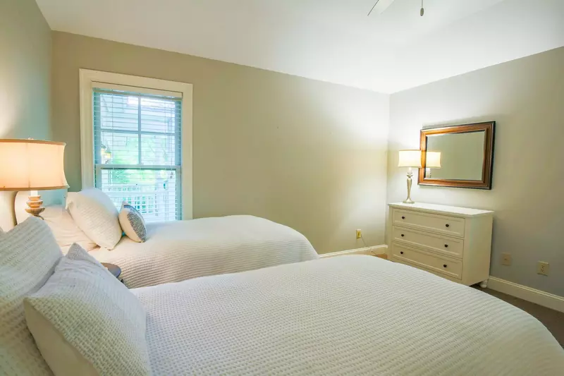 This guest bedroom also has a dresser and night stand with a reading lamp.
