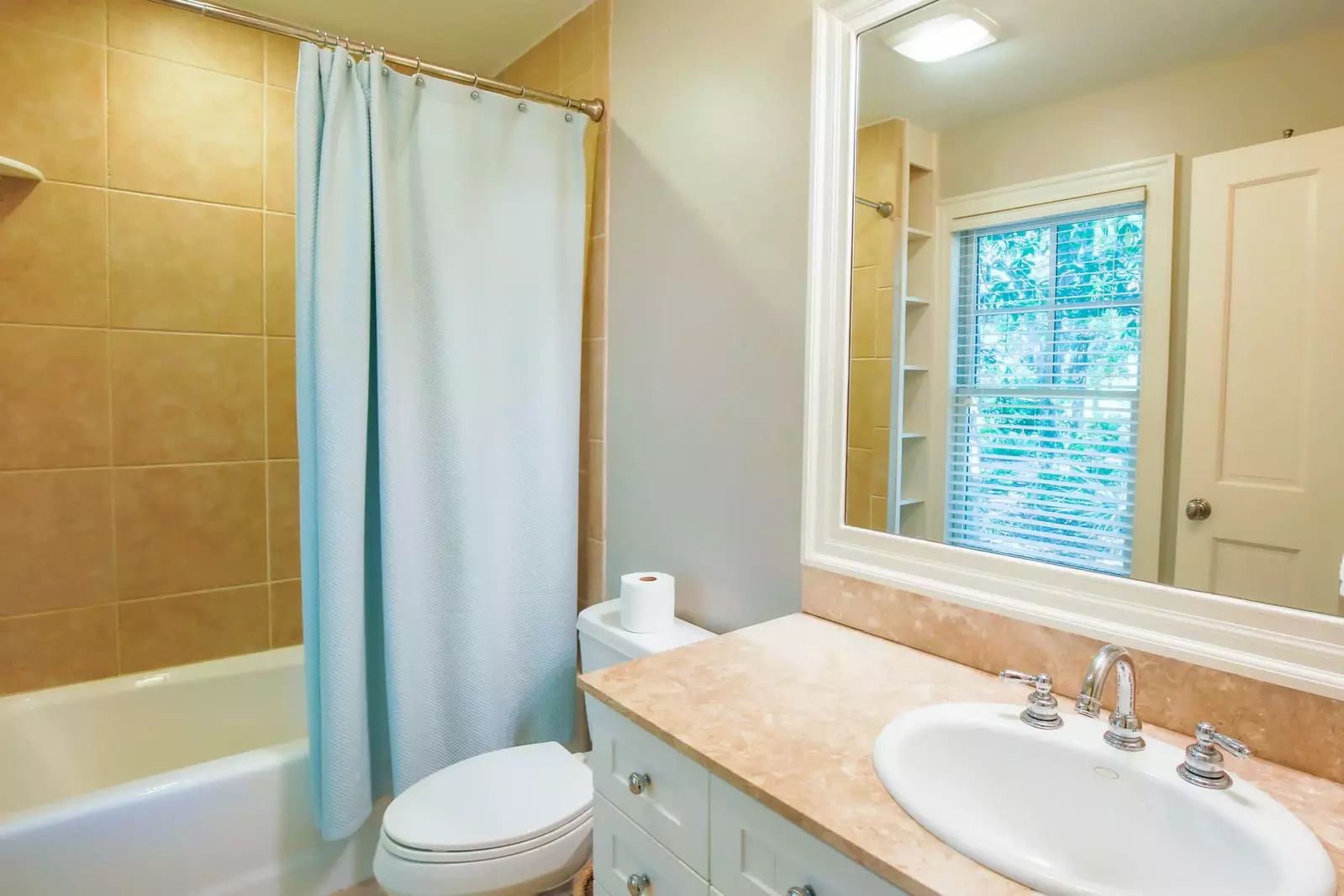 The en suite bathroom features a shower/tub combo and a spacious vanity.