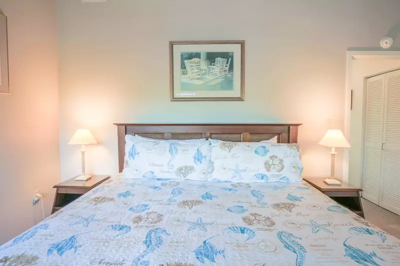 The master suite, which is located on the home's upper level, features a king bed and night stands with reading lamps.