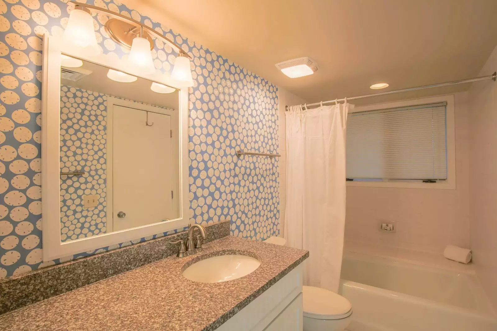 This bathroom with a large vanity and shower/tub combo is located on the home's lower level.