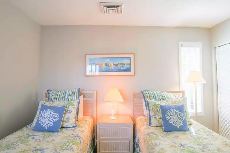 This room features two twin beds, a night stand and reading lamps.