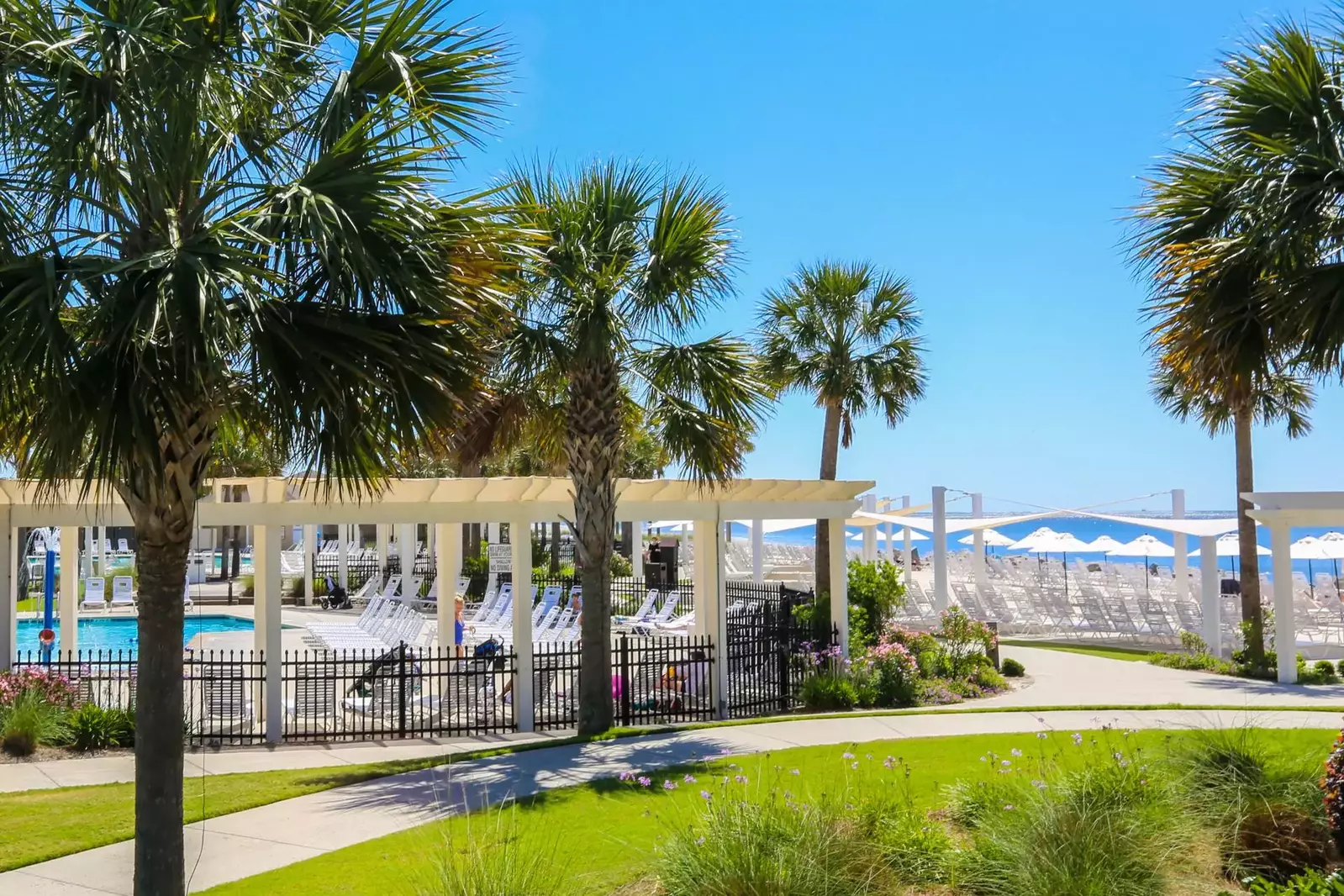 The Club features two sparkling, saltwater swimming pools and rows of lounge chairs with umbrellas.