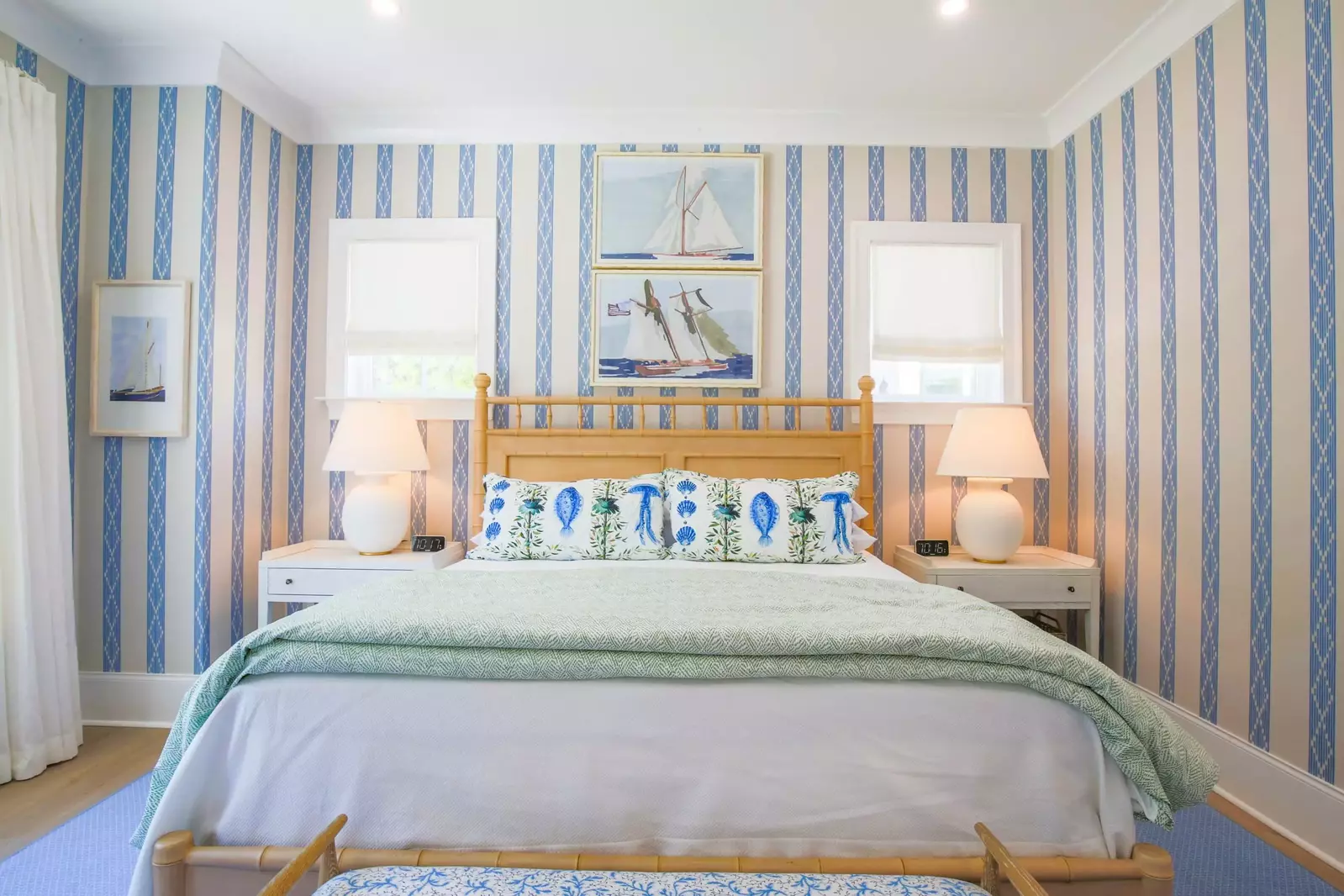 This master suite has a king bed, night stands with reading lamps and bench.