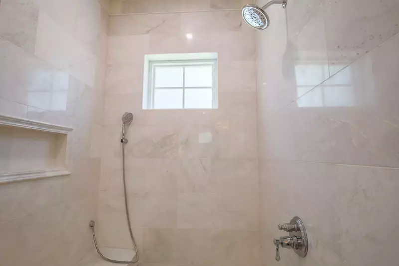 The en suite bathroom also has a walk-in shower with two shower heads and bench seating.