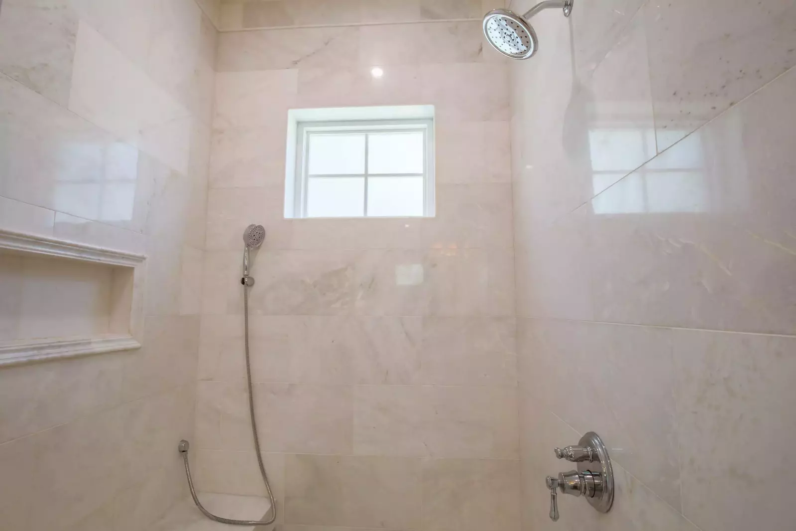 The en suite bathroom also has a walk-in shower with two shower heads and bench seating.