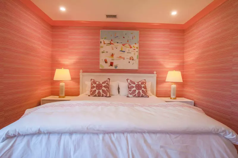 The second master suite features a king bed with night stands and reading lamps.