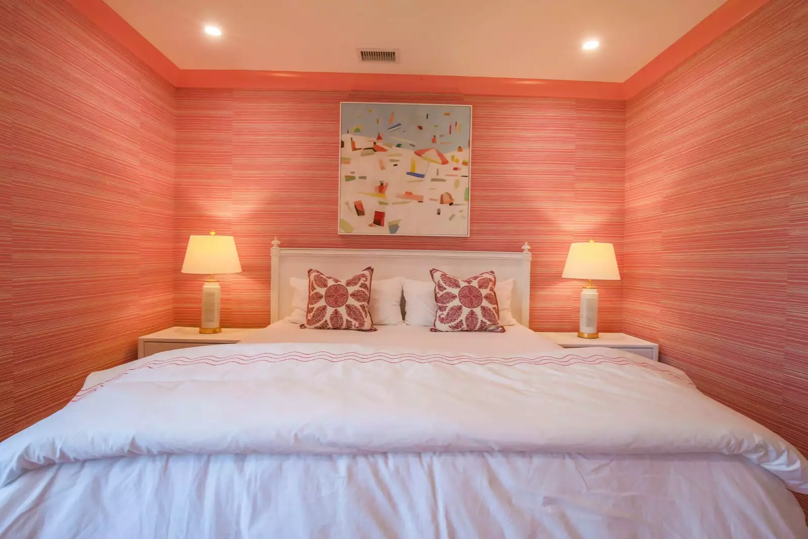 The second master suite features a king bed with night stands and reading lamps.