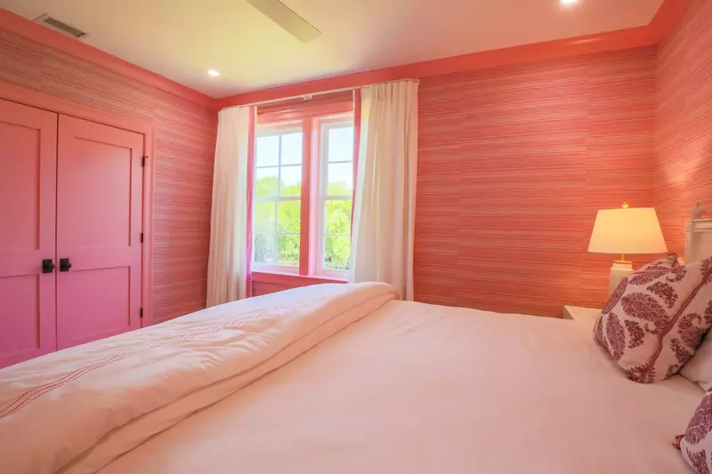 This suite has been decorated with pink trim and wallpaper.