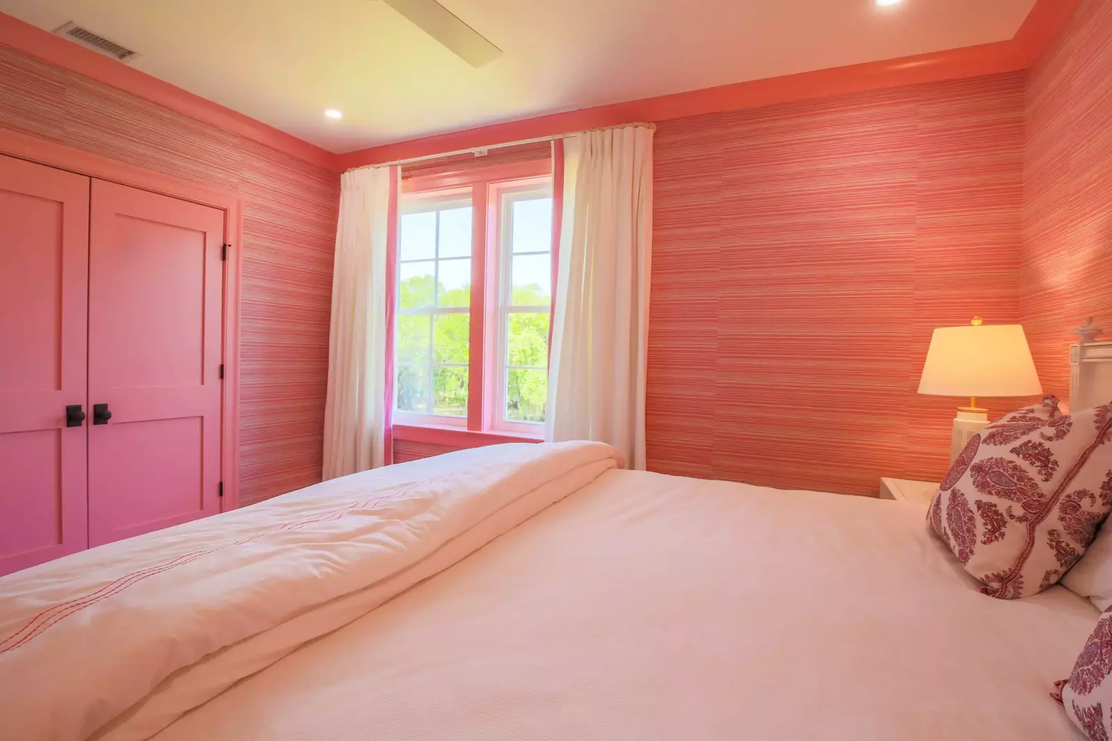 This suite has been decorated with pink trim and wallpaper.