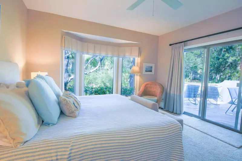 The primary suite features a king bed, access to the back porch and water views of the lagoon.