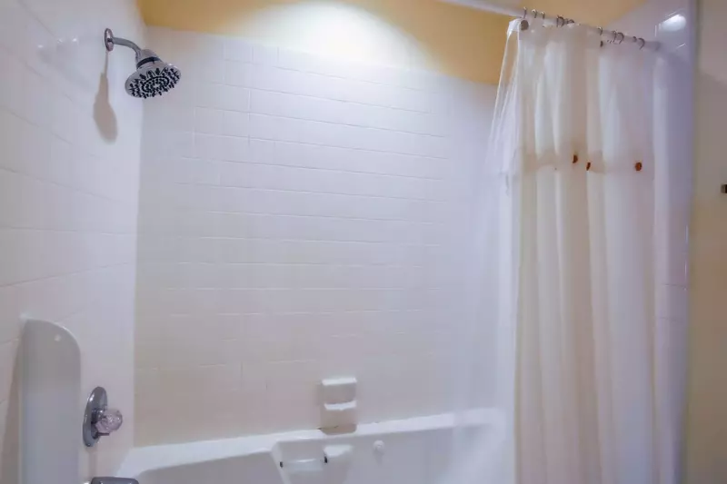 The primary bathroom also features this tiled, shower/tub combo.