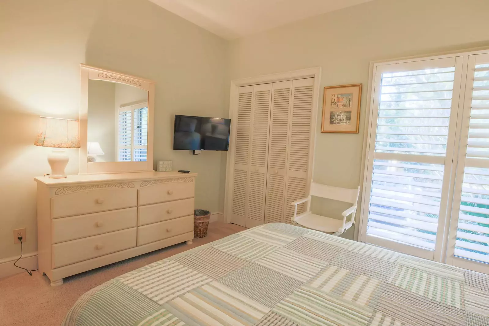 There is a dresser and wall-mounted cable TV in this guest bedroom.