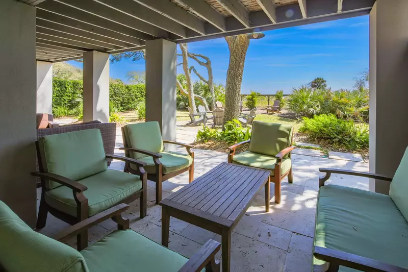 The lowest level on the oceanside of the house features a partially-covered patio with multiple seating areas.