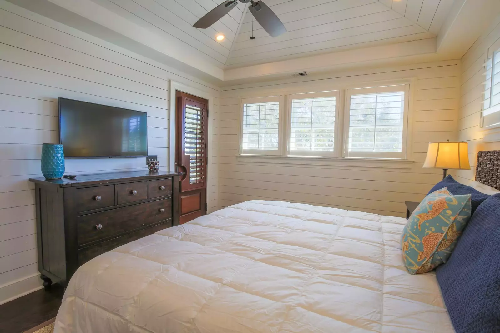 The master suite also has access to the covered porch, a dresser and mounted smart TV.