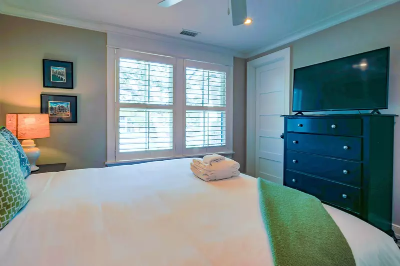This guest suite features a king bed, night stands with reading lamps and dresser with TV.