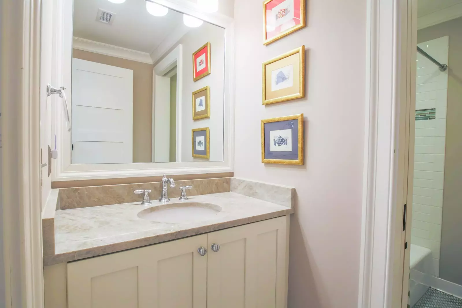 The en suite bathroom for this lower level guest suite features a shower/tub combo.