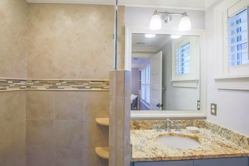 The en suite bathroom features a vanity and tiled, walk-in shower.