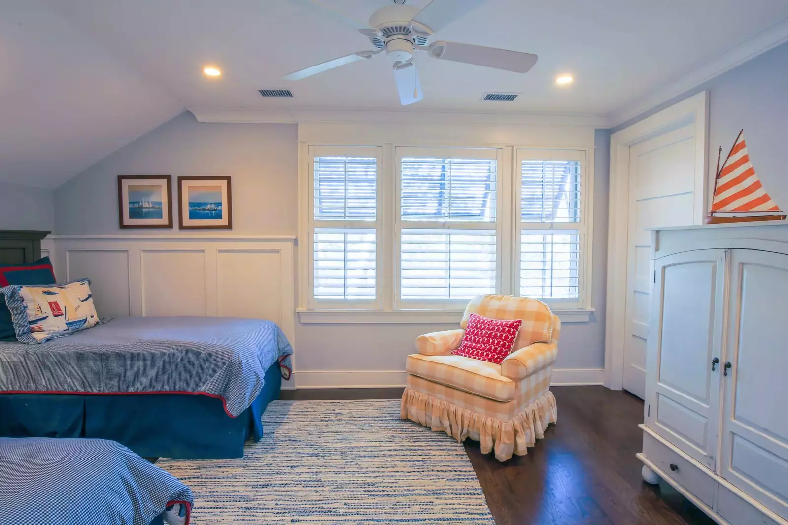 This guest bedroom also has an arm chair and an armoire (with a TV tucked away inside).